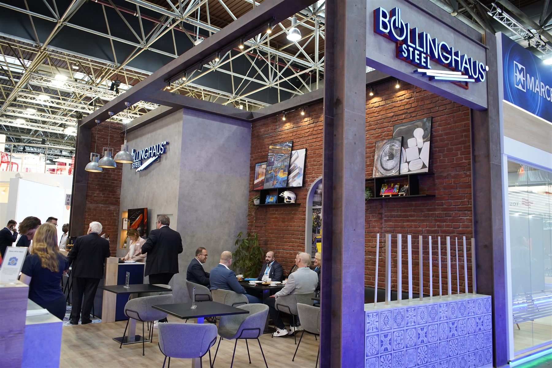 Böllinghaus Steel Messestand mit Backsteinwand, Loungebereich und Messinglicht