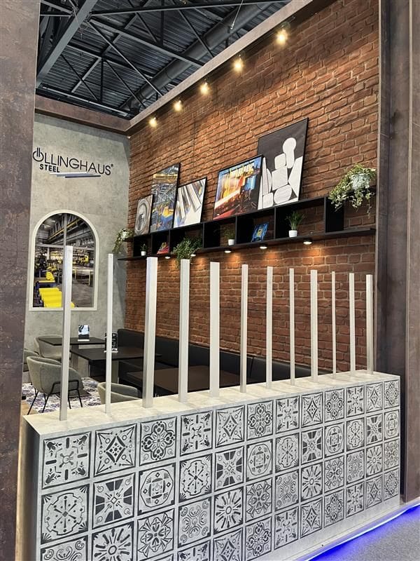 Detail des Böllinghaus Steel Messestands Stainless Steel 2025 Maastricht, Fliesentheke und Markenlogo an der Backsteinwand