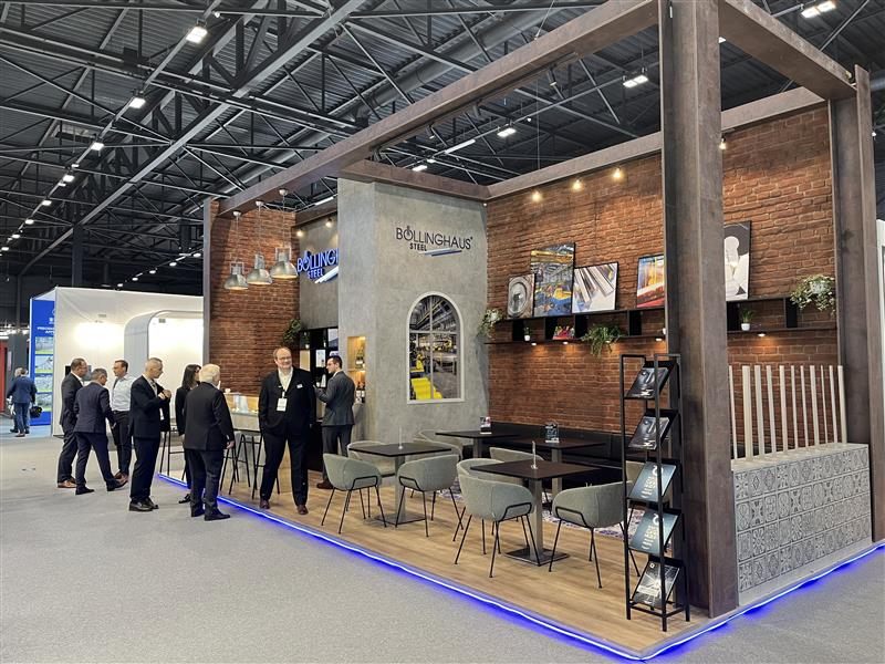 Böllinghaus Steel Messestand auf der Stainless Steel 2025 in Maastricht mit Loungebereich, Backstein und blauem Lichtband