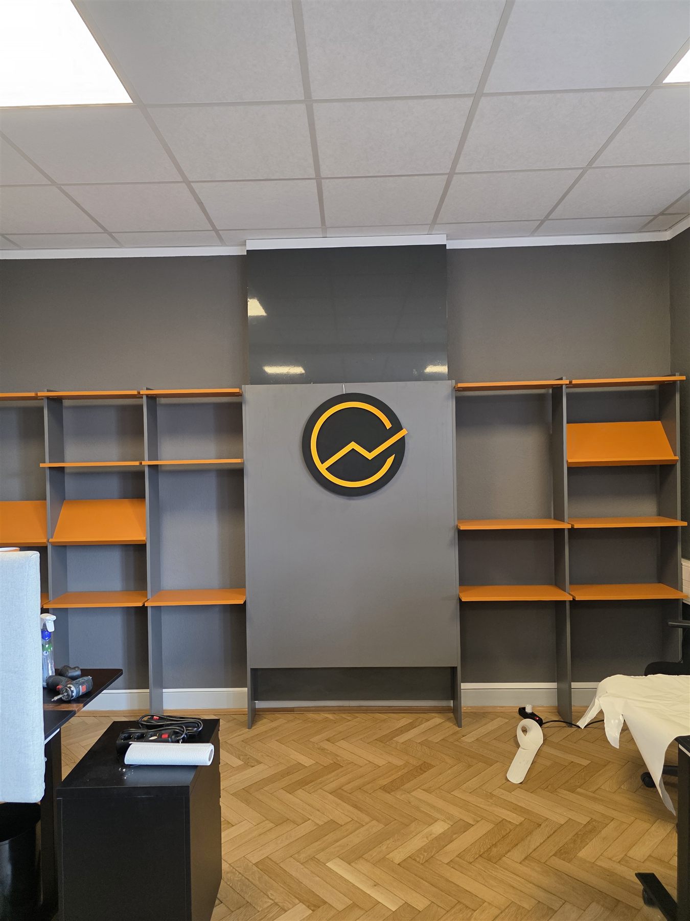 Bürogestaltung für Digitaler Unternehmenserfolg mit Regal und Logo an der Wand