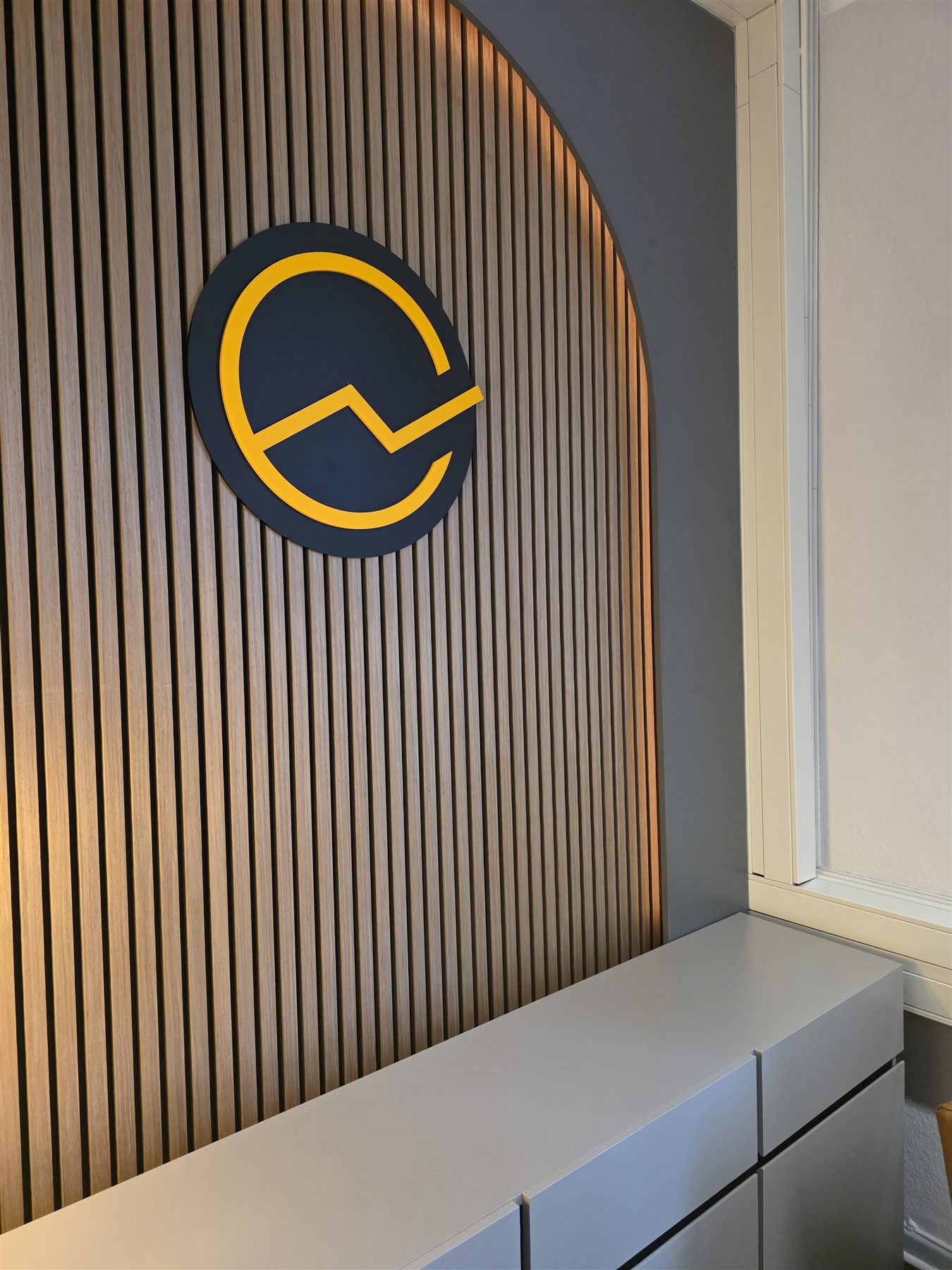 Holzlamellen-Wand mit Logo im Büro von Digitaler Unternehmenserfolg