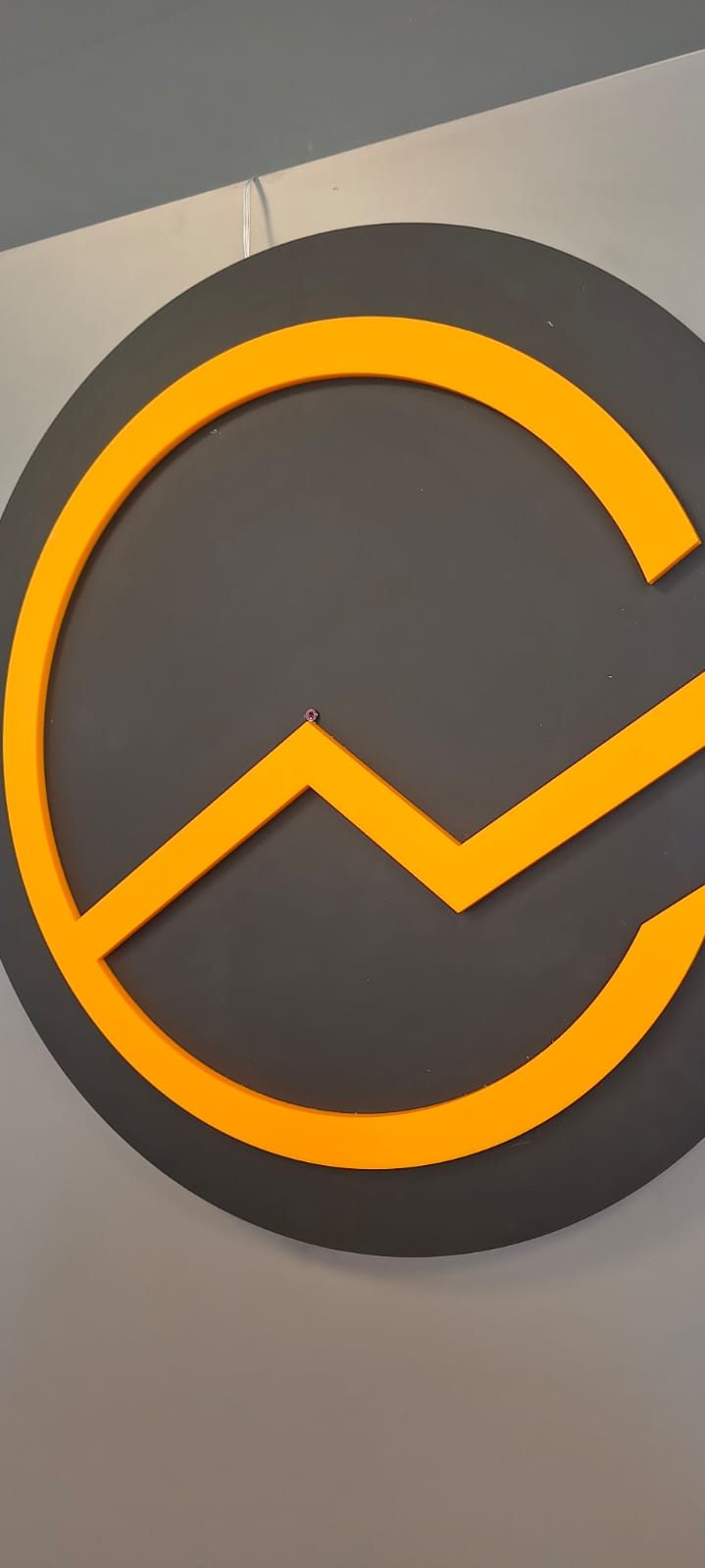 Orangefarbenes Logo auf anthrazitfarbener Wand, Digitaler Unternehmenserfolg