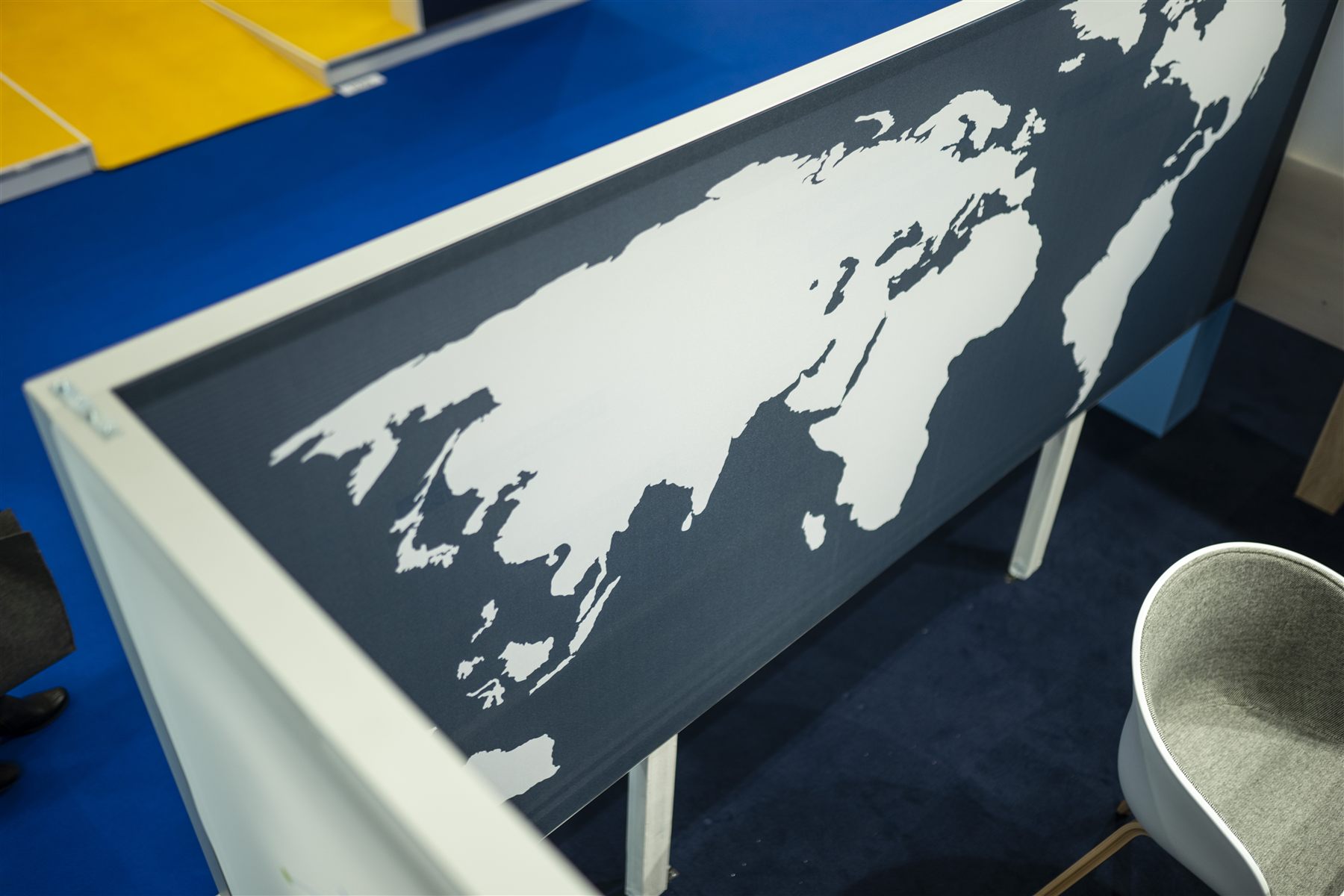 Tisch mit Weltkarten-Grafik und Flugrouten am Materna IPS Messestand