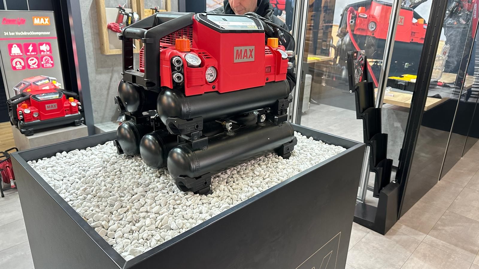 MAX Produkt auf beleuchtetem Podest am Messestand BAU München