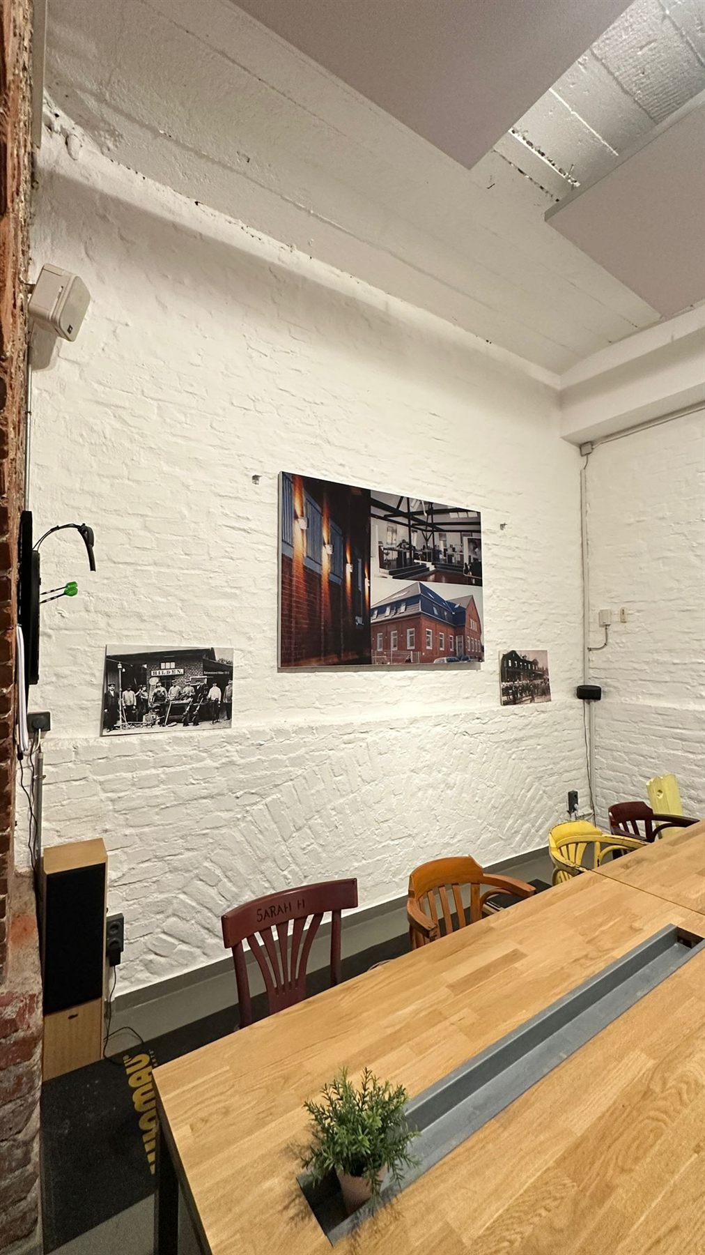 Holztisch vor Backsteinwand mit gerahmtem Bild bei Mönnighoff und Partner