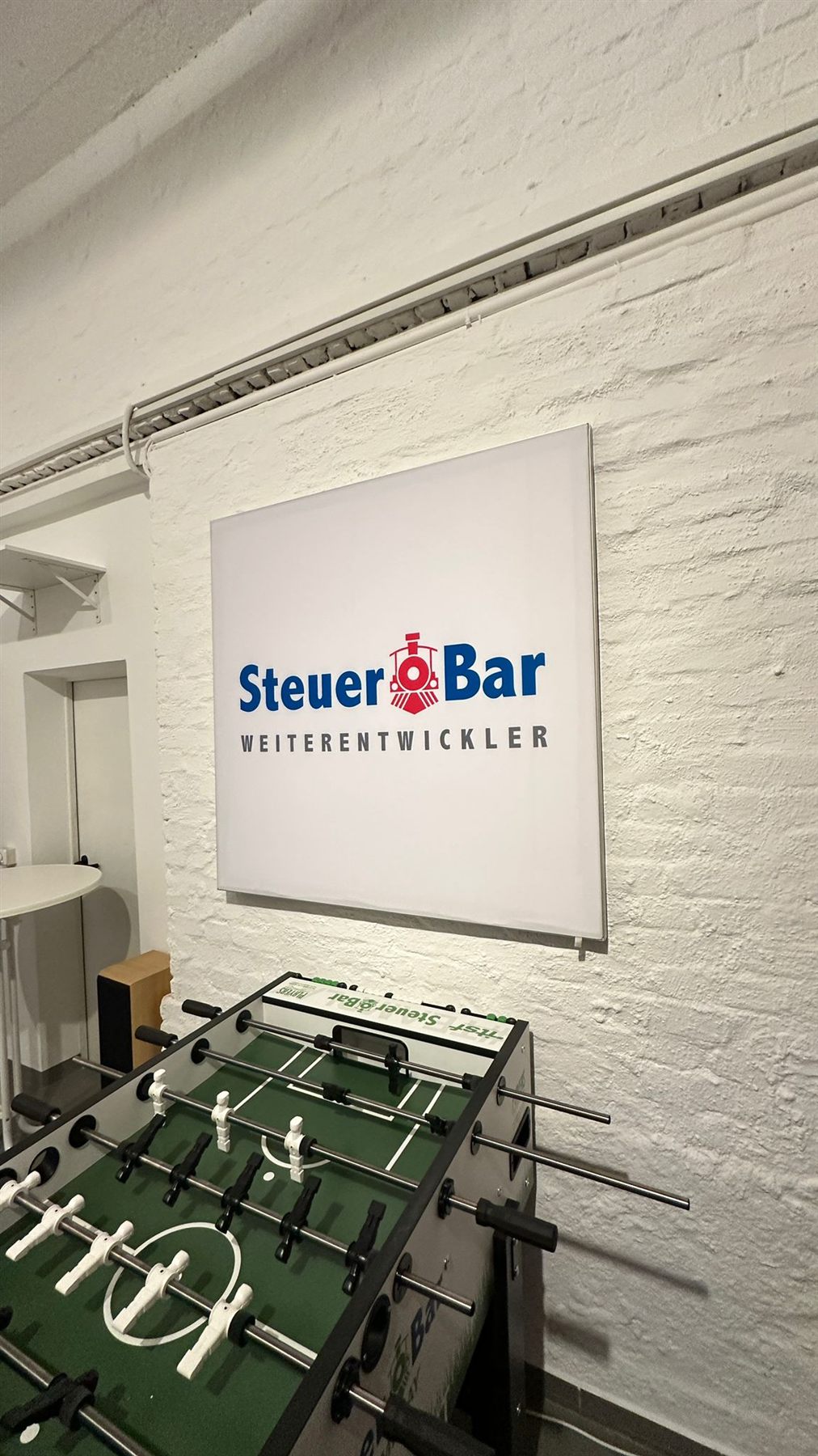 Die SteuerBar, ein gebrandeter Kicker im Raumkonzept von Mönnighoff und Partner